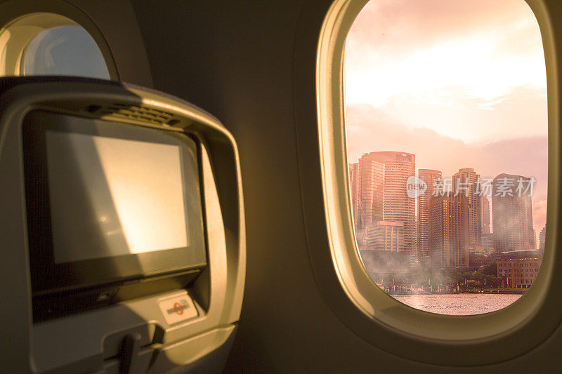 悉尼，新南威尔士州，澳大利亚。从机场起飞后，从飞机经济舱的窗口俯瞰日落/日出的天空。